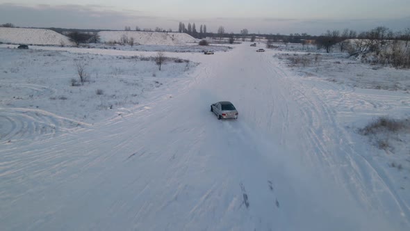 Sport car racing on snow race track in winter. Snow drifting. Driving a race car on a snowy road