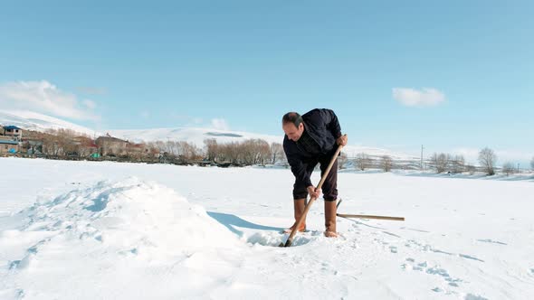 Fisherman Digging the Frozen Lake