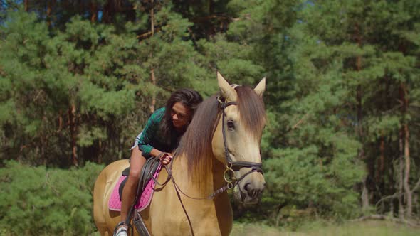 Caring Cute Female Rider Bending and Hugging Horse