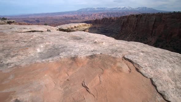 Walking to the edge of a steep canyon viewing rock spire