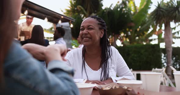 Multiracial people eating food truck gourmet meal outdoor - Healthy dinner concept