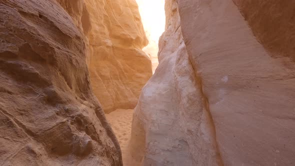 Narrow gorge between two high rocky colored orange mountains in Egypt Canyon site. Pan up to bright