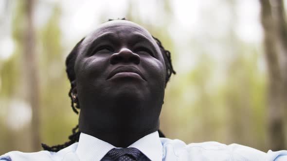 Close Up Shot of an African Businessman Having a Break in the Park. Slow Motion