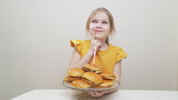 a Funny Little Girl Makes a Wish and Blows Out a Candle on a Hamburger Cake