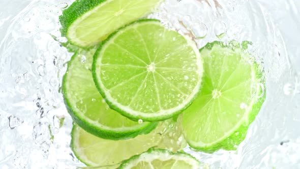 Super Slow Motion Shot of Lime Slices Falling Into Water Whirl at 1000 Fps