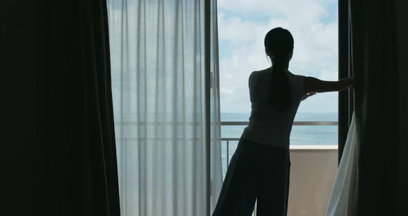 Woman open curtain at the morning