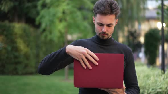 Portrait of Caucasian Young Businessman Closing Laptop Looking at Camera with Confident Facial