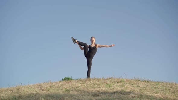 Standing Split of Confident Flexible Young Woman at the Background of Clear Blue Sky. Portrait of