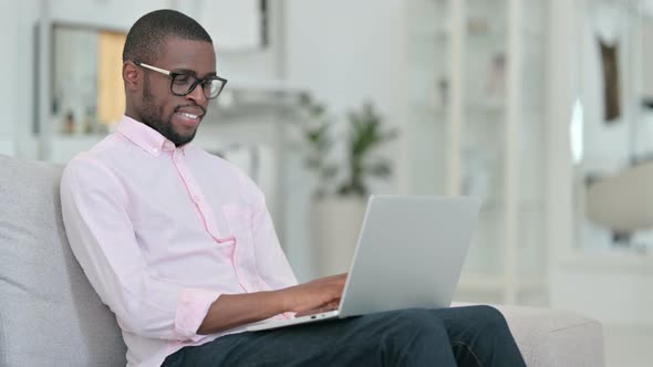 Hardworking Young African Man Working on Laptop at Home 