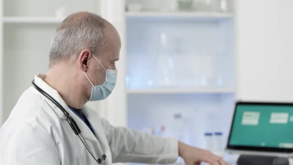 Doctor wearing face mask holding up covid-19 kit