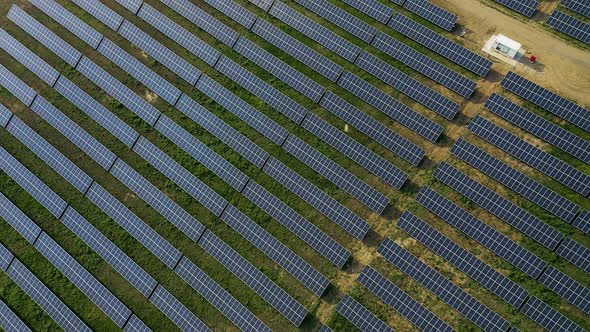 Aerial View of a Solar Panel Farm with Rows of Panels Drawing Energy From the Sun at Sunset