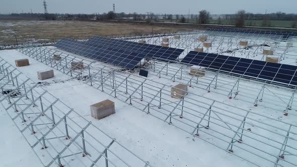 Drone is Flying Over the Mounting Racks and Solar Panels Snow Construction