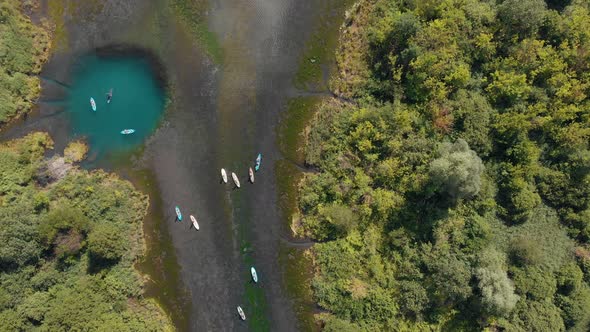 People Sailing on Canoe Shaped Boats on River