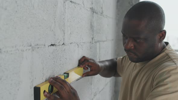 Black Man Using Level Tool at Home