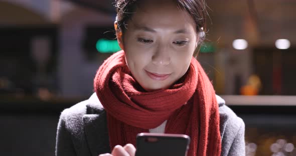 Young Woman use of smart phone in city at night