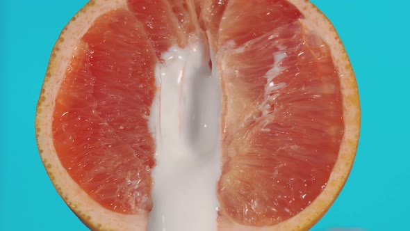 Leaking of white liquid from the half of grapefruit, indicating sexual intercourse, sex.