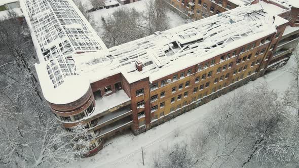 A Multistorey Building with a Destroyed Roof Covered with Snow After a Blizzard