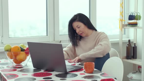 Adult business woman typing on laptop computer working in internet