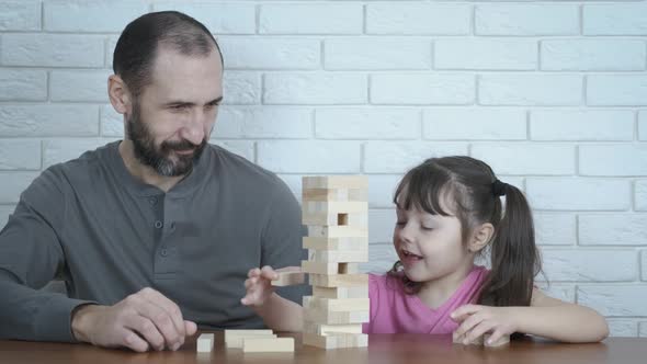 The family plays the game with wooden blocks.