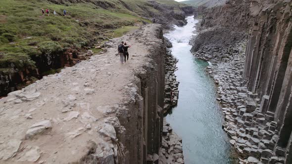 Aerial Shot of Studlagil Canyon  Tourists Walking By the Cliff