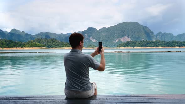 Man Filming Blog or Vlog or Video Chat on Mobile Phone at Amazing Lake