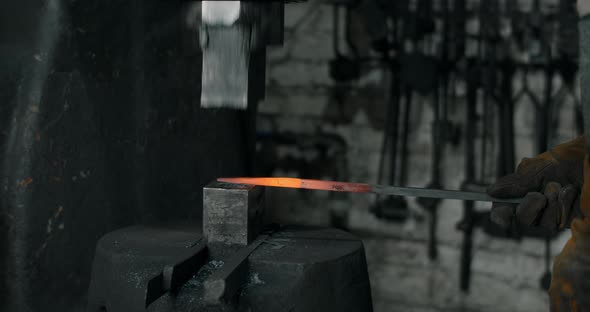 Blacksmith Uses a Hydraulic Hammer to Forge Hot Metal in His Workshop Automatic Hammer is Shaping