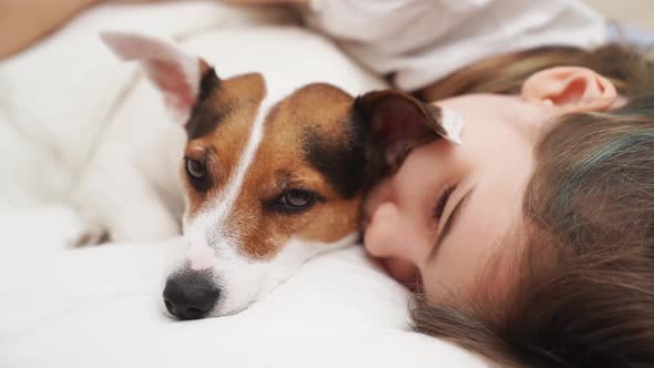 A Teenage Girl Sleeps with Her Dog in Bed
