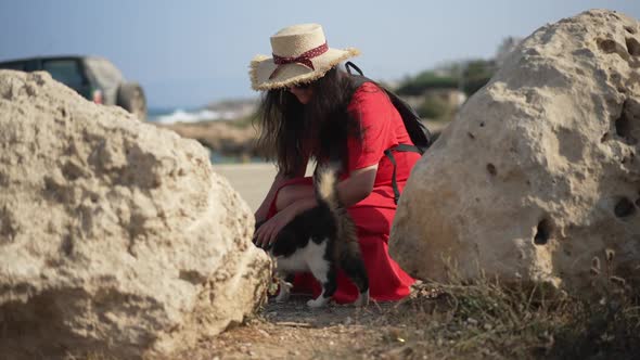 Happy Woman Stroking Cat in Slow Motion Sitting on Hunkers in Sunshine Outdoors