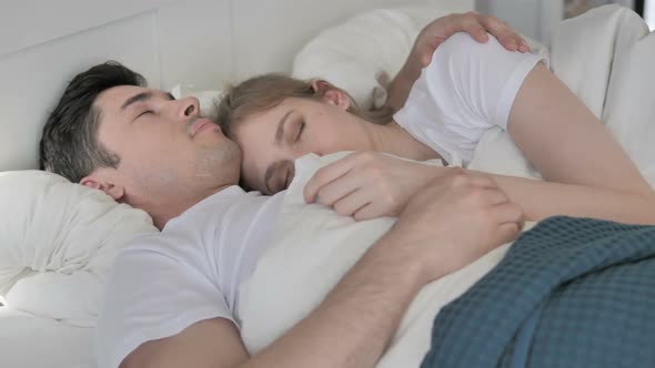 Cuddling Couple Sleeping in Bed