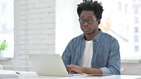 Young African Man Working and Showing Thumbs Up