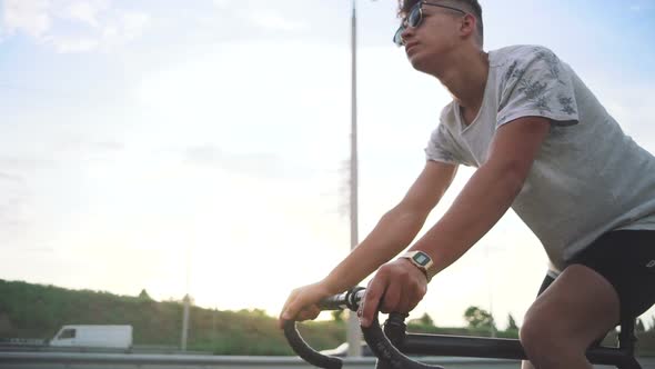 Young Handsome Hipster Man Riding Fixed Gear Bicycle During Sunset Outdoor