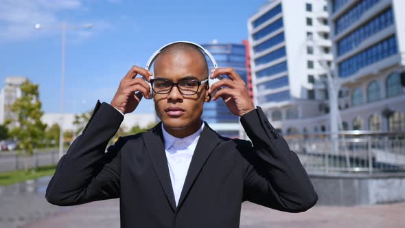 Portrait Of Handsome Diverse Businessman Wearing Wireless Headphones And Glasses