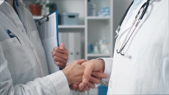 Happy Meeting Of Medical Practitioners. Two Doctors In White Coats Who Shake Hands Say Hello