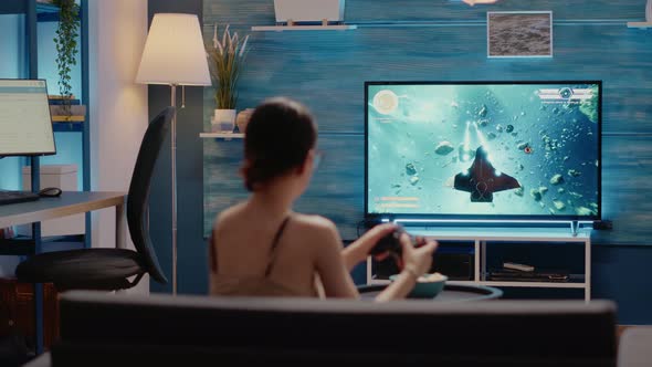 Young Woman Holding Wireless Joystick in Living Room