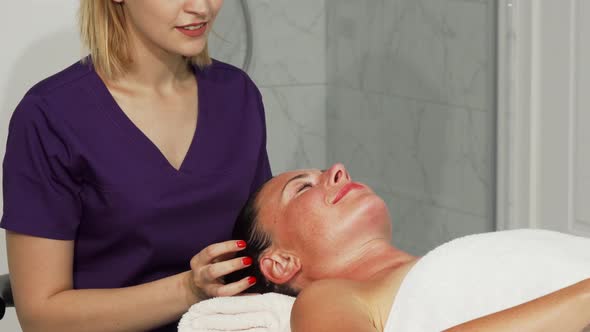 Relaxed Happe Woman Getting Head Massage at Spa Center