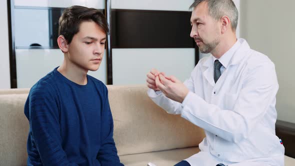 The doctor puts on a teen's behind-the-ear hearing aid