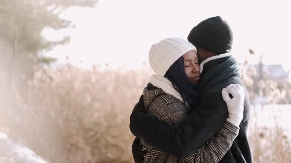 African American Couple Hugging in the Snowy Forest