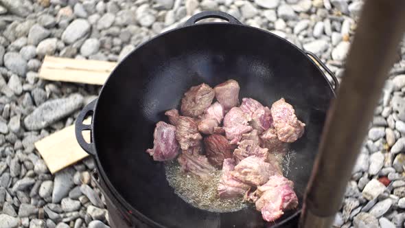 Stewing Meat for Uzbek Pilaf in a Cauldron