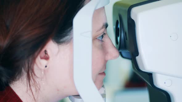 A Lady is Looking Into an Eyeschecking Machine