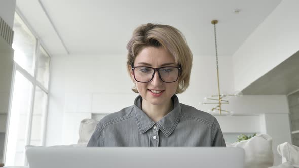 Smiling Blonde Lady Freelancer in Glasses Types on Laptop