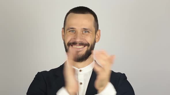 Handsome Young Businessman Smiling and Actively Clapping Hands, Greeting New Customers