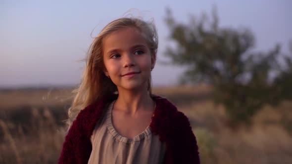 Round Footage of Cute Caucasian Blondie Girl Wearing Soft Red Cardigan Standing in the Middle of