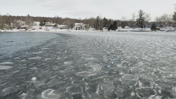 Ice sheets ripple with waves across lake surface