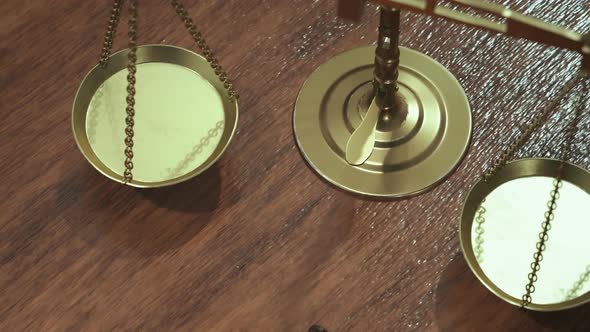 Libra or scale with gavel on a wooden desk as a symbol of law and justice.