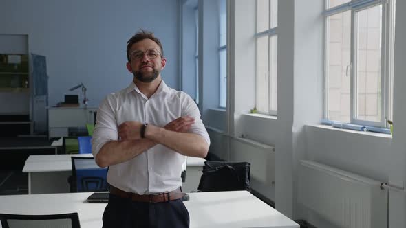 Man Stands in Company Office and Crosses His Hands