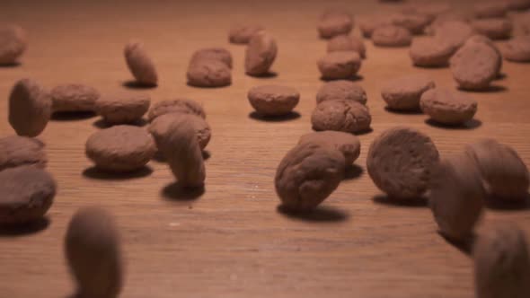 Traditional Dutch candy rolling on a wooden surface. Slow motion shot.