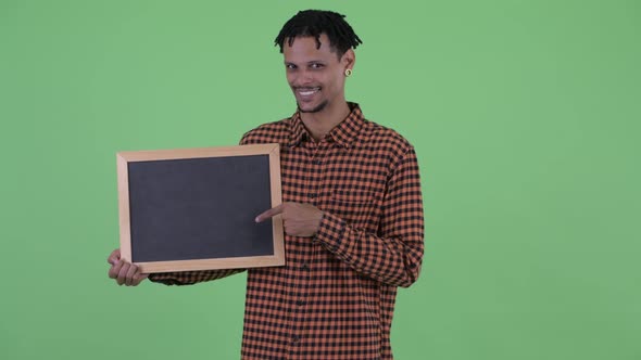 Happy Young African Man Holding Blackboard and Giving Thumbs Up