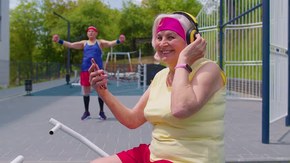 Senior Woman After Sport Training Listening Music From Mobile Phone Wearing Headphones on Playground