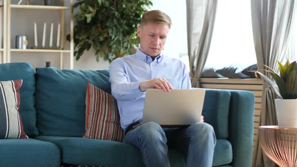 Middle Aged Man Closing and Laptop and Leaving Office