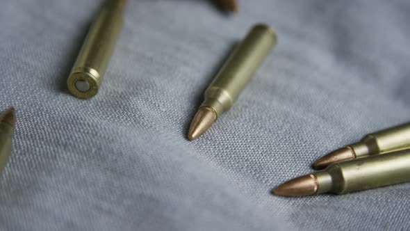 Cinematic rotating shot of bullets on a fabric surface 
